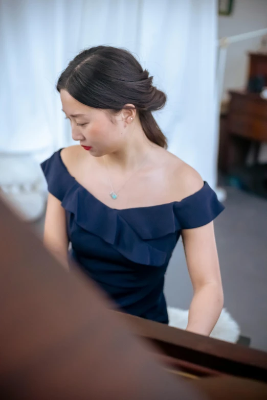 a woman in a blue dress playing a piano, inspired by Zheng Xie, unsplash, open neck collar, portrait image, wearing elegant jewellery, alexandria ocasio cortez