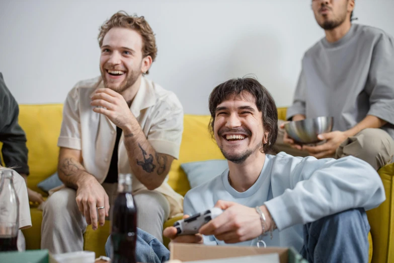 a group of men sitting on top of a yellow couch, pexels contest winner, happening, eating chips and watching tv, avatar image, smiling laughing, playing games