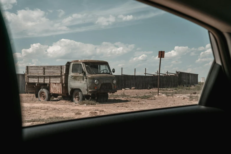 a truck that is sitting in the dirt, an album cover, unsplash, soviet suburbs, new mexico, an olive skinned, movie filmstill