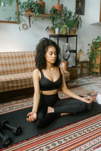 a woman sitting on a yoga mat in a living room, by Adam Marczyński, trending on pexels, renaissance, light skinned african young girl, a cyborg meditating, low quality photo, breathing
