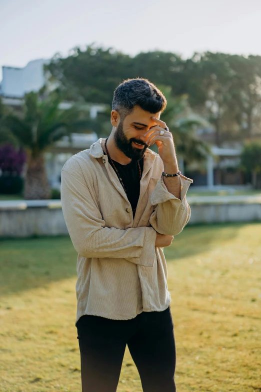 a man standing in a field talking on a cell phone, an album cover, by Ismail Acar, pexels contest winner, wearing casual clothes, shady look, young greek man, profile pic