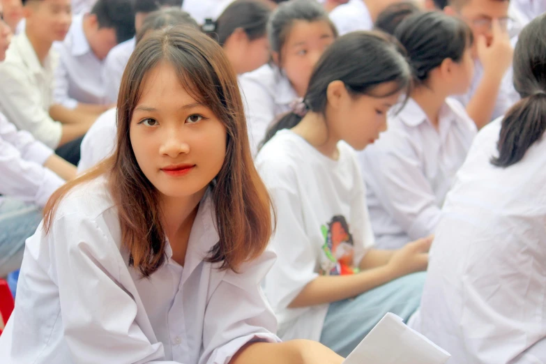 a woman sitting in front of a group of people, high school girls, dao trong le, avatar image, academic clothing