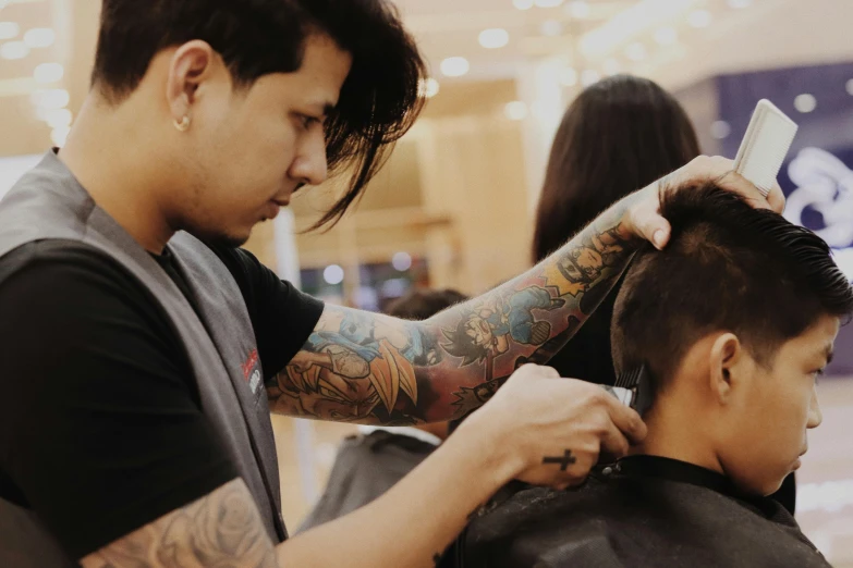 a man getting his hair cut at a barber shop, a tattoo, by Kanbun Master, pexels contest winner, cindy avelino, with textured hair and skin, half asian, half cut