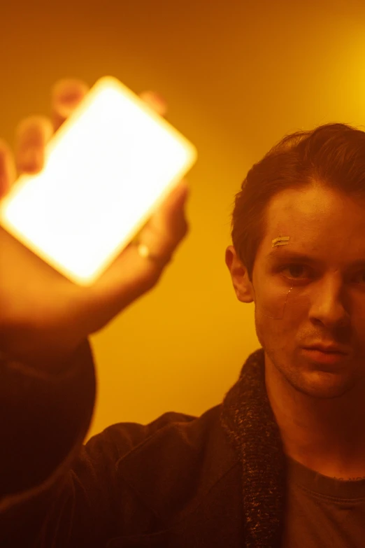 a man holding a cell phone in his hand, a hologram, by Jacob Toorenvliet, jamie campbell bower, solid cube of light, ignant, she has fire powers