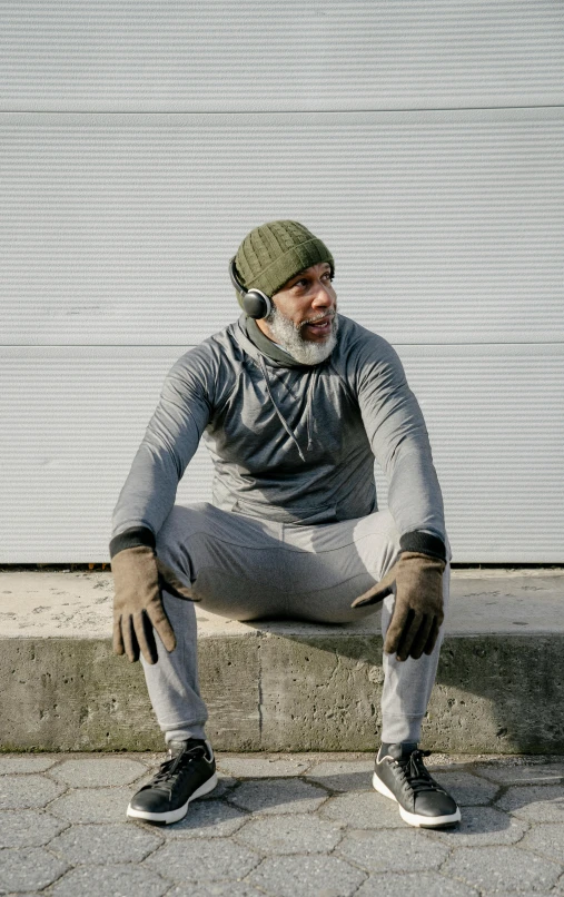 a man sitting on a curb with a skateboard, inspired by Jan Müller, happening, balaclava mask, light grey, with head phones, male polar explorer