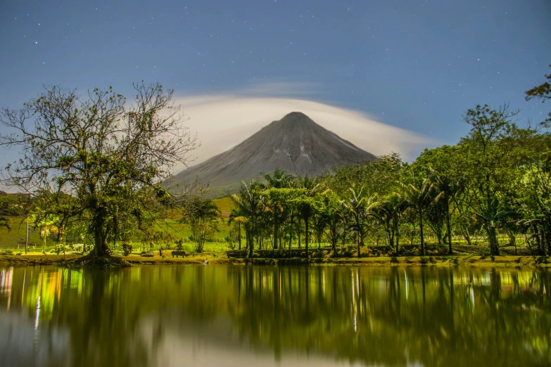 a body of water with a mountain in the background, by Niklaus Manuel, lush forests, in a volcano, moonbow, slide show