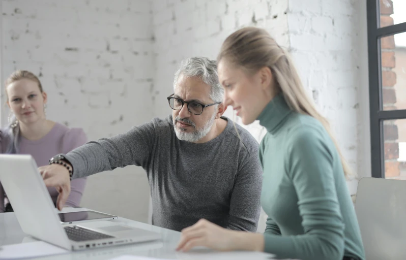 a couple of people sitting at a table with a laptop, dark grey haired man, thumbnail, it specialist, convincing