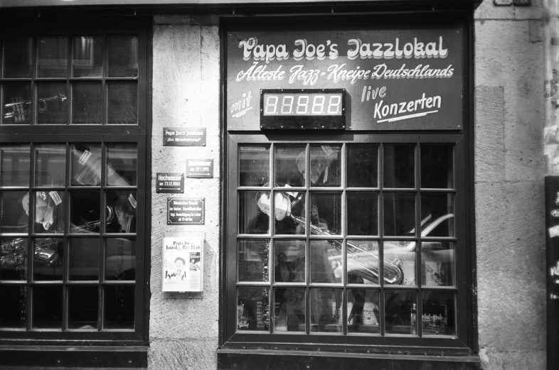 a black and white photo of a store front, a photo, by Josef Dande, pexels, dada, pizza!, joe, jukebox, puzzle