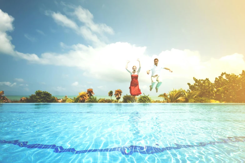 a man and a woman jumping into a swimming pool, by Elaine Hamilton, pexels contest winner, sunny day with clear sky, wedding, photoreal octane render, holiday