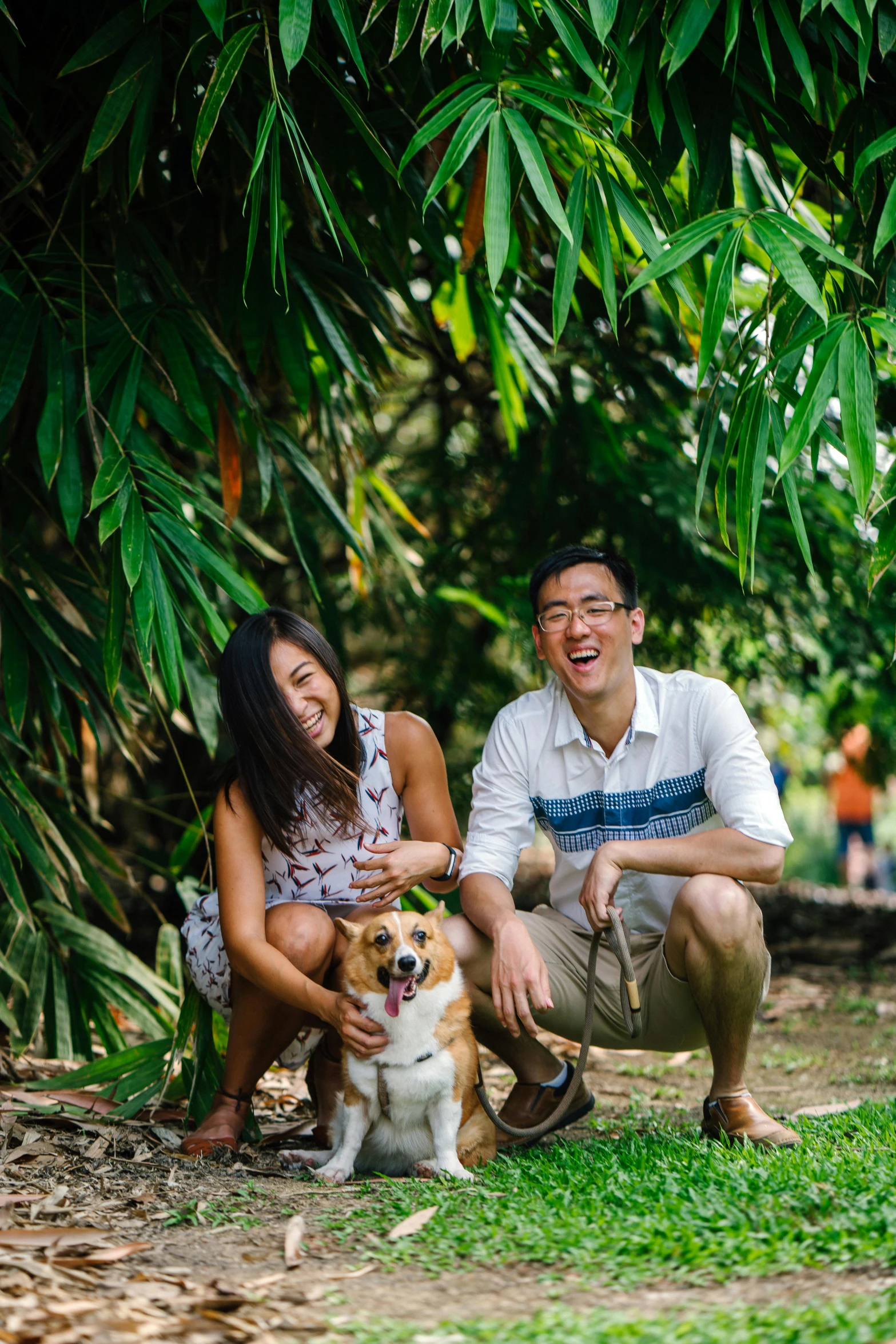 a man and woman pose for a picture with a dog, a picture, pexels contest winner, in the tropical wood, joy ang, bushes in the background, singapore ( 2 0 1 8 )