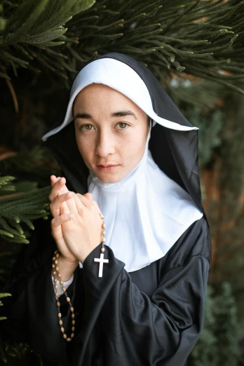 a woman dressed as a nun holding a rosary, by Julia Pishtar, dilraba dilmurat, non-binary, holiday, avatar image