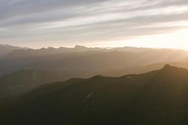 a couple of people standing on top of a mountain, by Brigette Barrager, unsplash contest winner, sunset panorama, ominous! landscape of north bend, viewed from bird's-eye, morning light showing injuries