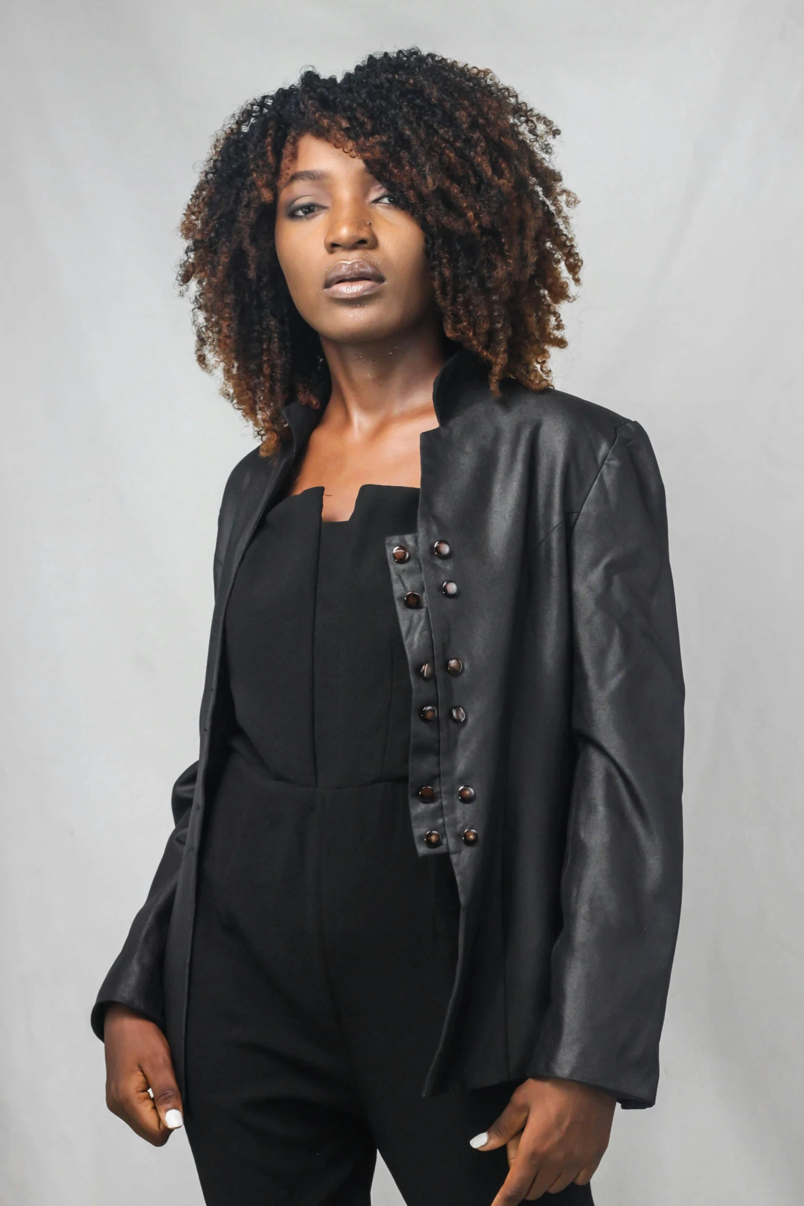 a woman wearing a black jacket and pants, inspired by Theo Constanté, unsplash, renaissance, ebony skin, front facing, metal garments, all black matte product