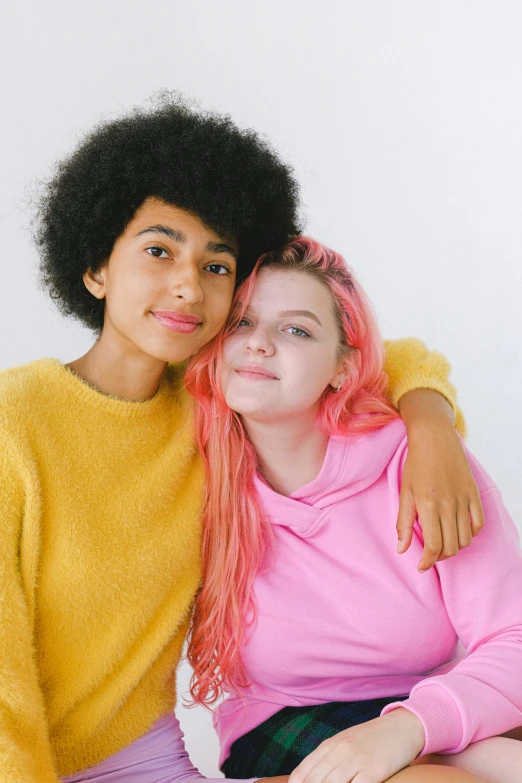 a couple of women sitting next to each other, trending on pexels, renaissance, pink and yellow, portrait of white teenage girl, embracing, mixed race