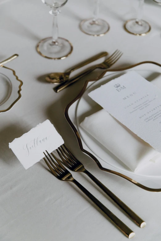 a white table topped with plates and silverware, unsplash, baroque, invitation card, deckle edge, zoomed in, label