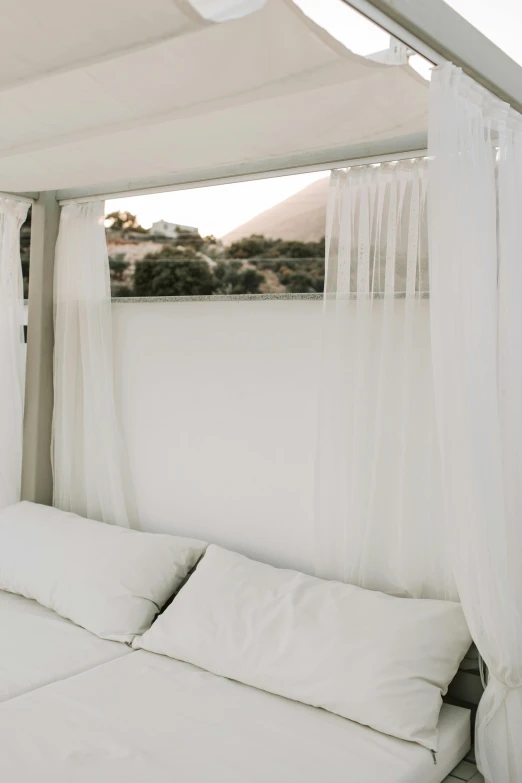 a white bed sitting under a canopy next to a window, by Matt Cavotta, hills in the background, low quality photo, on clear background, multiple stories