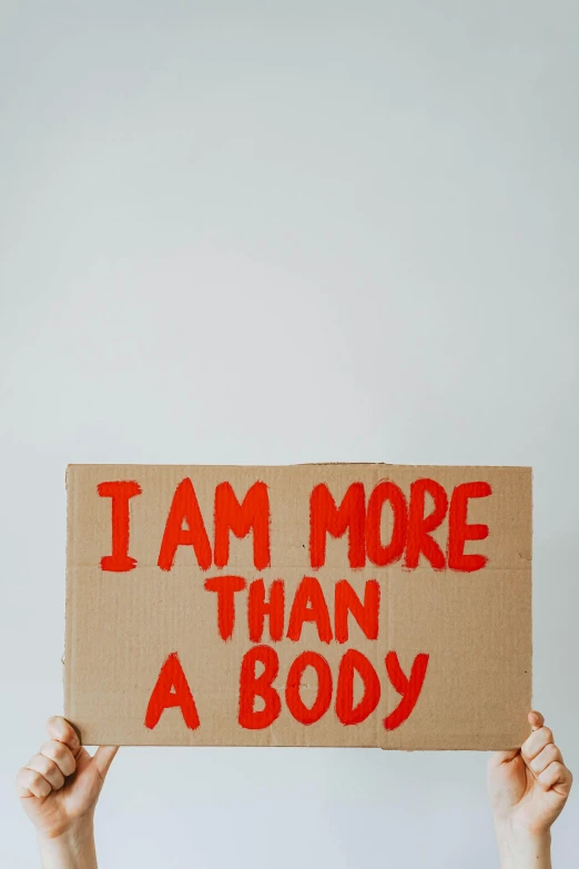 a person holding a sign that says i am more than a body, a poster, pexels, happening, biological, cut out, all body, instagram post