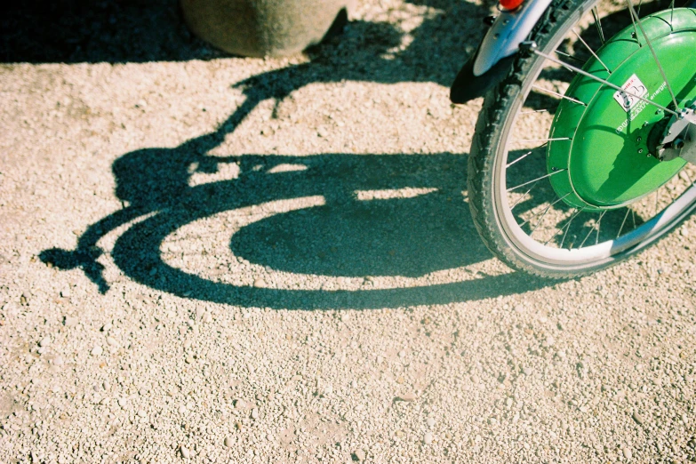 a green bicycle parked next to a potted plant, by Nathalie Rattner, unsplash, long shadows, avatar image, tyre mark, grainy film photo