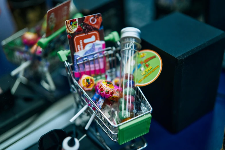 a shopping cart filled with candy sitting on top of a counter, by Joe Bowler, pexels contest winner, toyism, test tubes, bong, discovery zone, cyberpunk marketplace