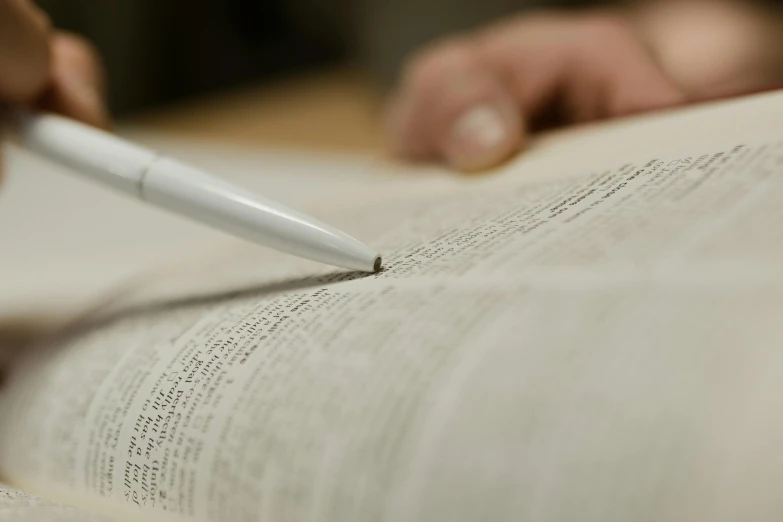 a person holding a pen and writing on a book, large text, subtle details, thumbnail, book library studying