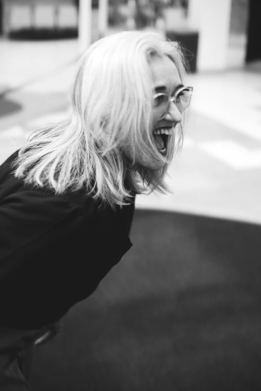 a black and white photo of a woman laughing, a black and white photo, by Leo Leuppi, one girl has white hair, girl with glasses, girl screamin yolo - aesthetic, saoirse ronan