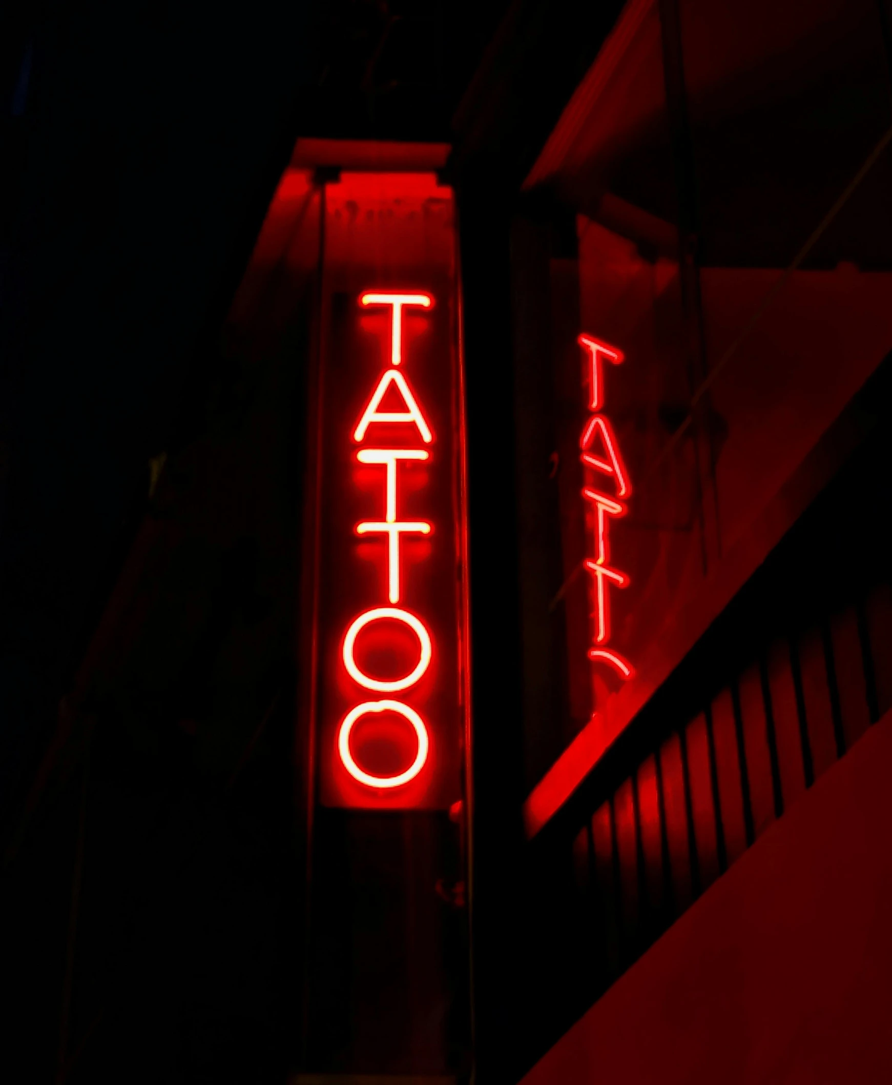 a neon sign for a tattoo parlor lit up at night, a tattoo, pexels contest winner, gothic tattoos, red ink, #trending, journalism photo