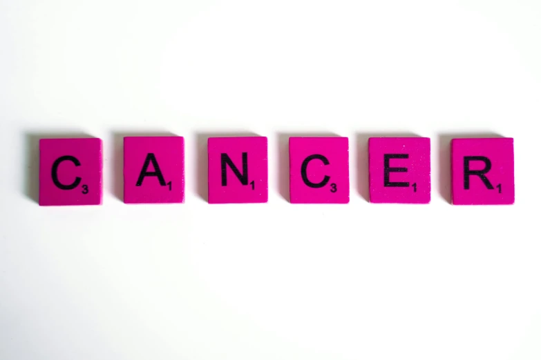the word cancer spelled in scrabbles on a white surface, a photo, by David Garner, pexels, renaissance, dance, the walls are pink, panels, alexis franklin