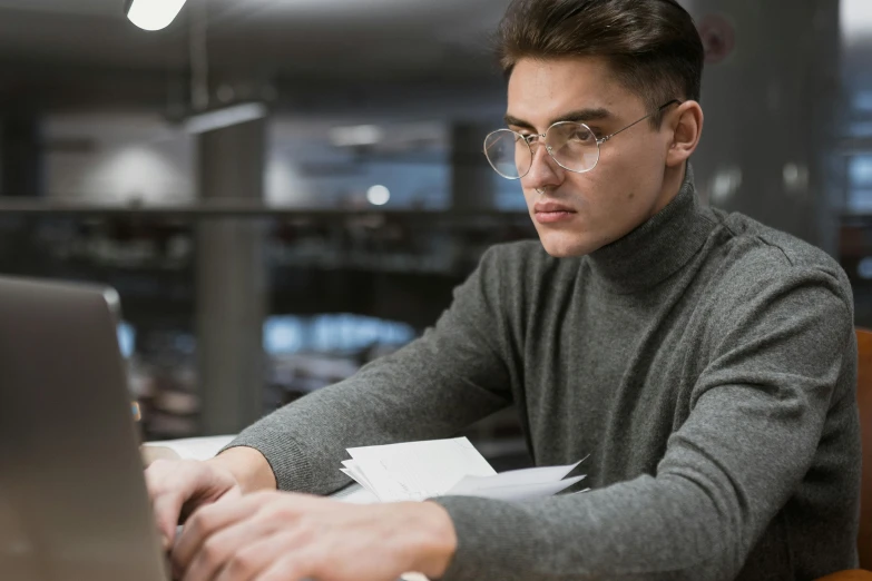 a man sitting in front of a laptop computer, trending on pexels, academic art, androgynous person, wearing reading glasses, f 1 driver charles leclerc, man wearing a closed cowl