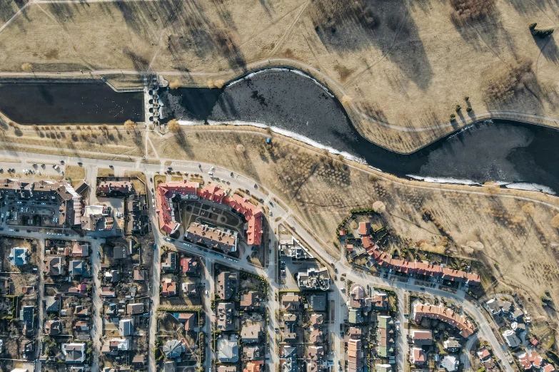 a bird's eye view of a city with a river running through it, a photo, by Adam Marczyński, ruined subdivision houses, open street maps, highresolution, drone footage
