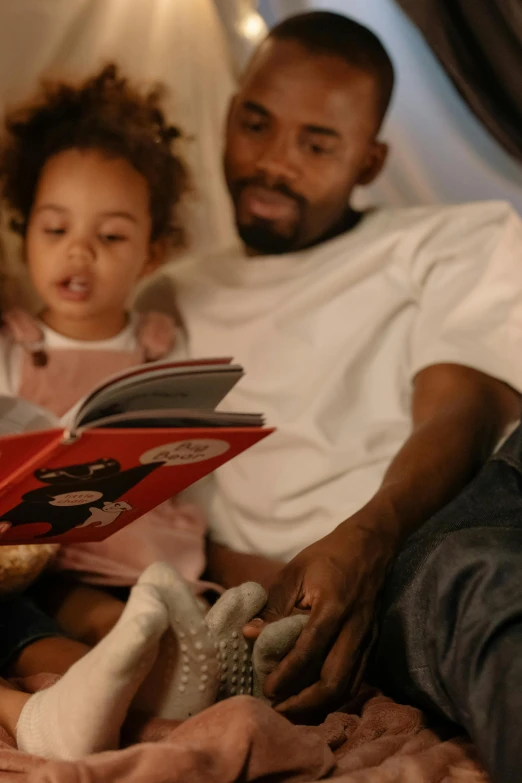 a man reading a book to a little girl, by Everett Warner, pexels, figuration libre, ( ( dark skin ) ), square, cinematic still, banner