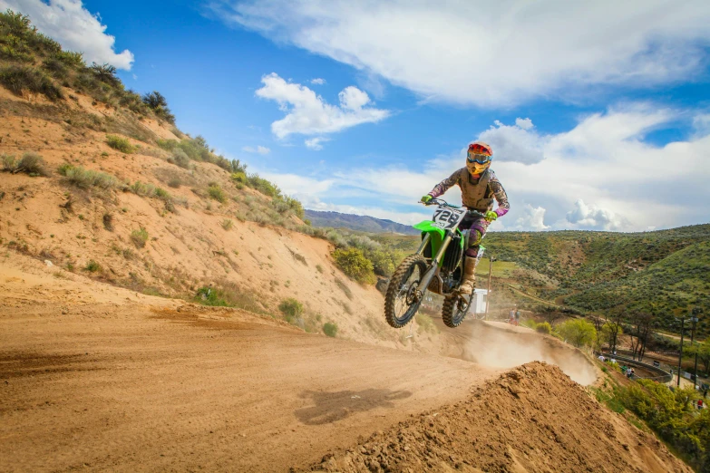 a man riding a dirt bike on top of a dirt hill, unsplash, figuration libre, green flag, avatar image, colorado, in an action pose