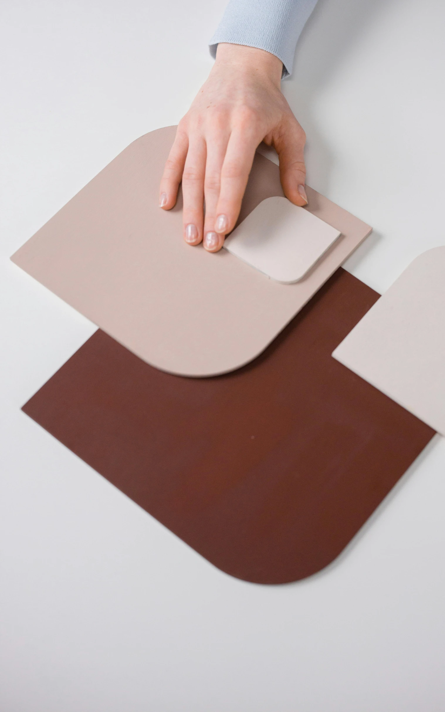 a person using a mouse pad on a table, inspired by Bauhaus, color field, clay material, brown, diecut, synthetic skin