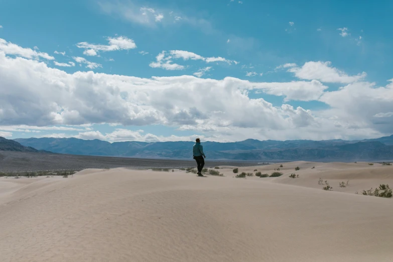 a person riding a horse in the desert, death valley, tiny person watching, unsplash 4k, standing alone in grassy field
