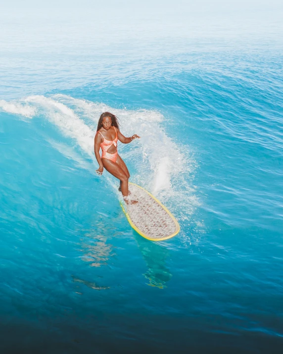 a woman riding a wave on top of a surfboard, wearing pearl neon bikini, tan complexion, sza, birds eye