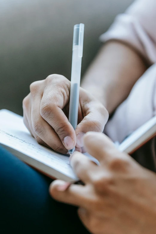 a person holding a pen and writing on a notebook, happening, thumbnail, multiple stories, geri keary, super high resolution