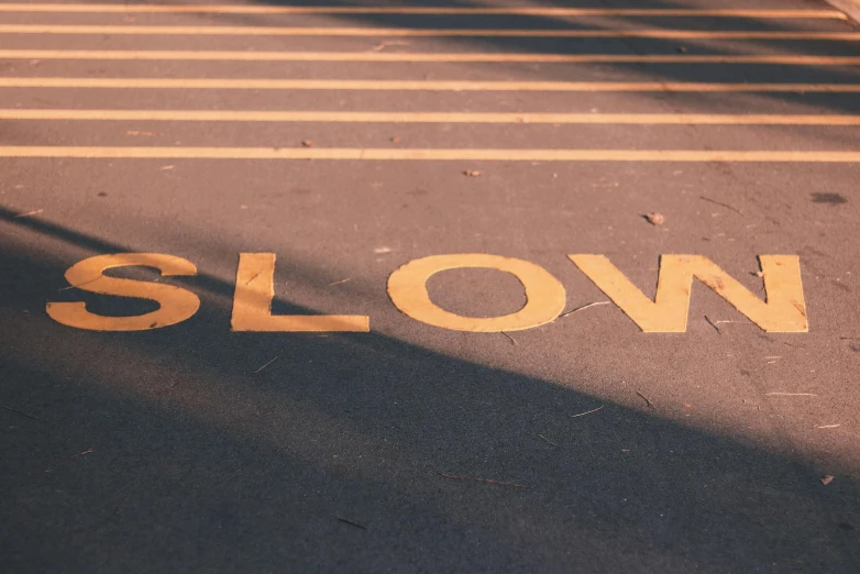 a yellow slow sign sitting on the side of a road, by Godfrey Blow, trending on unsplash, warm glow coming the ground, strokes, a blond, in a row