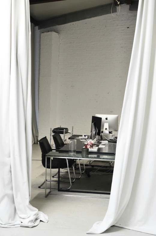 a room with a desk and a white curtain, inspired by Marina Abramović, unsplash, in a open-space working space, dwell, photography ultrafine detail, private moment