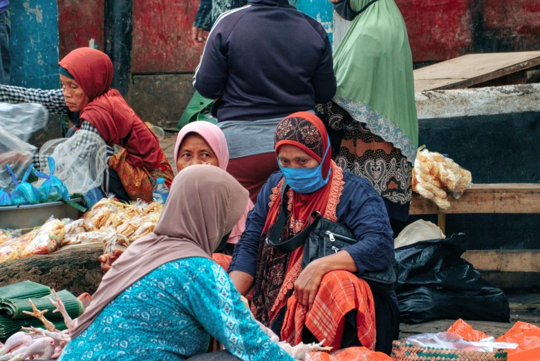 a group of women sitting next to each other at a market, pexels contest winner, hurufiyya, balaclava covering face, thumbnail, square, indonesia