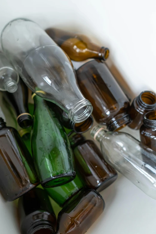 a pile of empty bottles sitting on top of a table, unsplash, assemblage, glass openings, brown, a green, eco