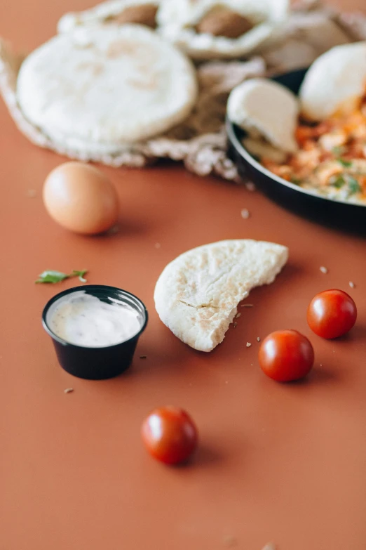 a pan filled with food sitting on top of a table, a still life, by Adam Marczyński, trending on unsplash, dau-al-set, mozzarella, middle eastern skin, solid background, cooking pizza