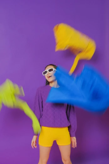 a woman in a purple shirt and yellow shorts, inspired by Bert Stern, trending on pexels, color field, abstract claymation, excitement, shades, toys