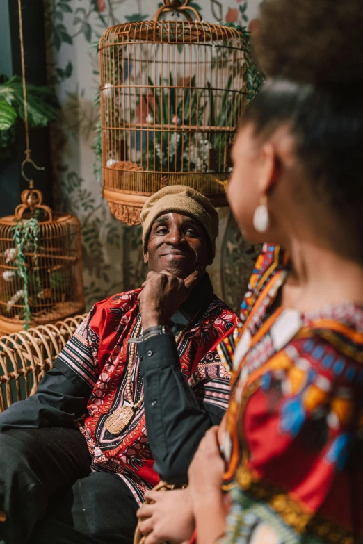 a man sitting on top of a couch next to a woman, inspired by Ras Akyem, pexels contest winner, black arts movement, wearing authentic attire, lush surroundings, promotional image, sentimental