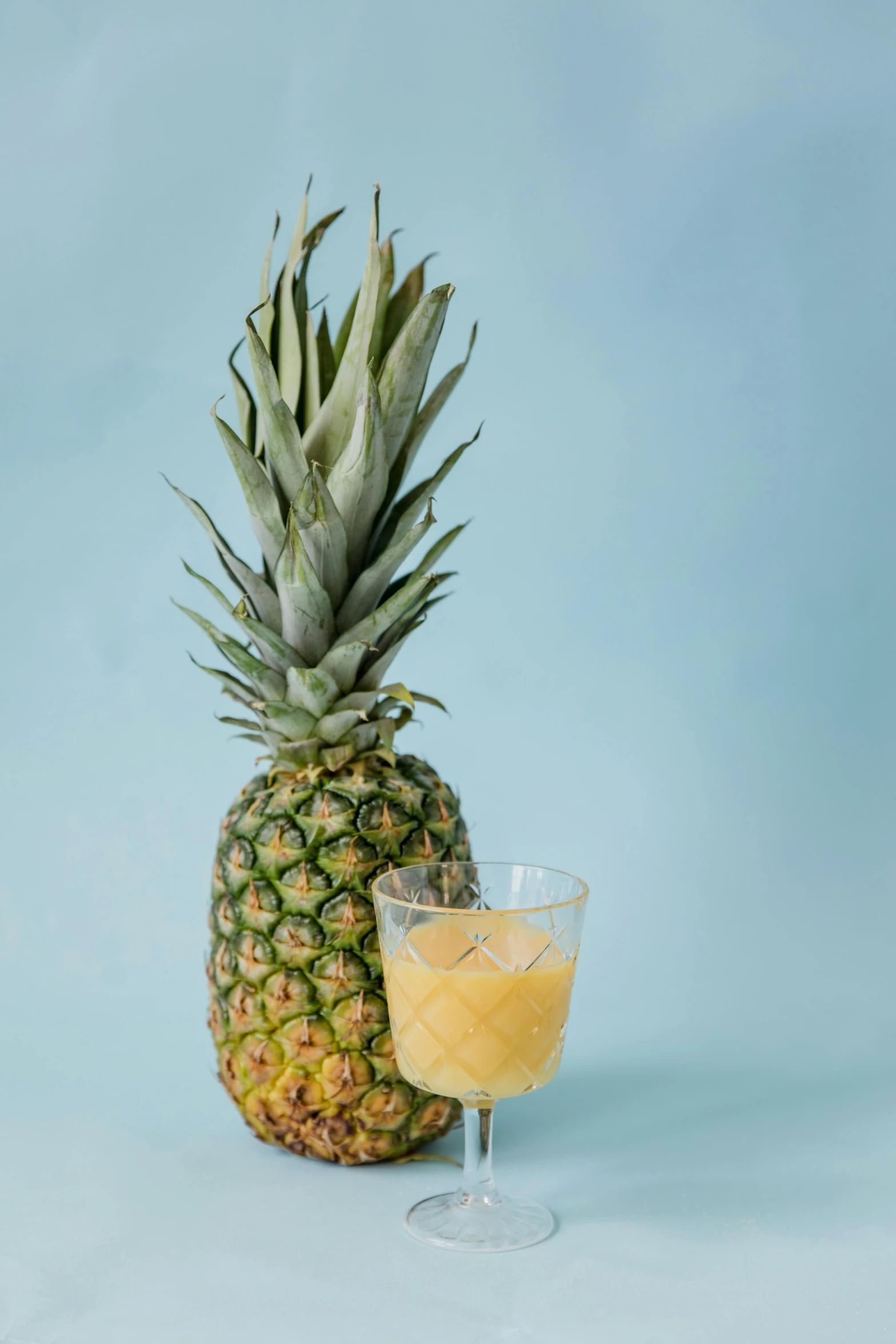 a pineapple next to a glass of orange juice, renaissance, on clear background, tropical undertones, 5 feet away, icy