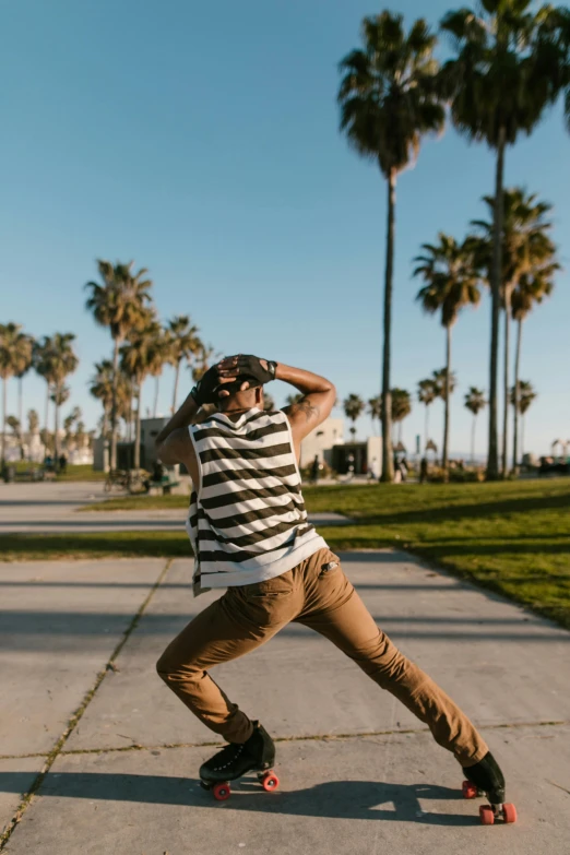 a man riding a skateboard down a sidewalk, unsplash contest winner, dancing on a tropical beach, wearing stripe shirt, california;, fight pose