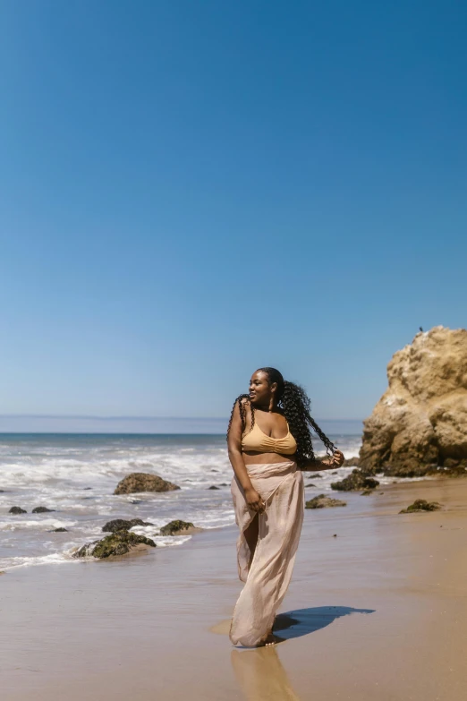 a woman standing on a beach next to the ocean, lizzo, malibu canyon, profile image