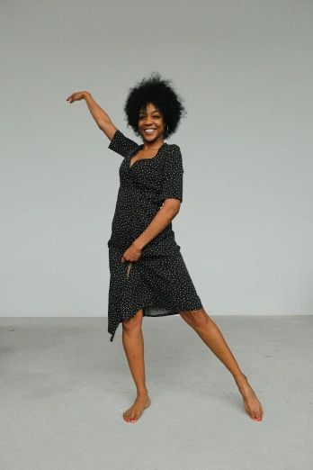 a woman in a black dress is dancing, unsplash, happening, patterned clothing, confident relaxed pose, square, ebony