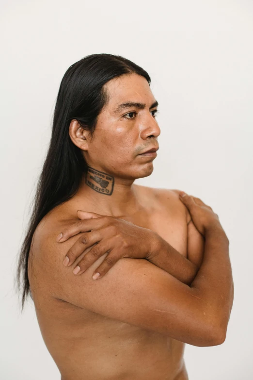 a man with a tattoo on his chest, trending on unsplash, renaissance, native american, plain background, long flowing black hair, gay