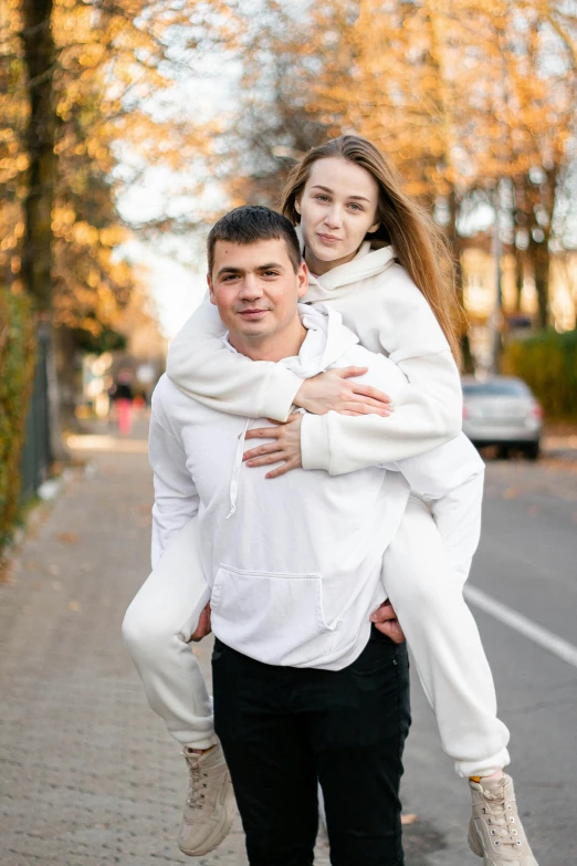 a man carrying a woman on his back, pexels contest winner, wearing a white sweater, russian girlfriend, wearing a track suit, a long-shot