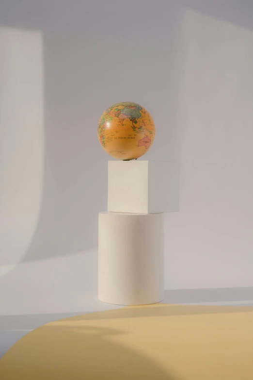 a globe sitting on top of a white pedestal, packaging of the world, (light orange mist), ignant, opal