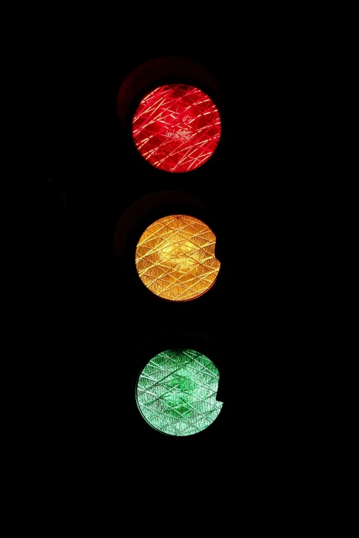 a close up of a traffic light at night, 3 colours, against a deep black background, circular, 3delight